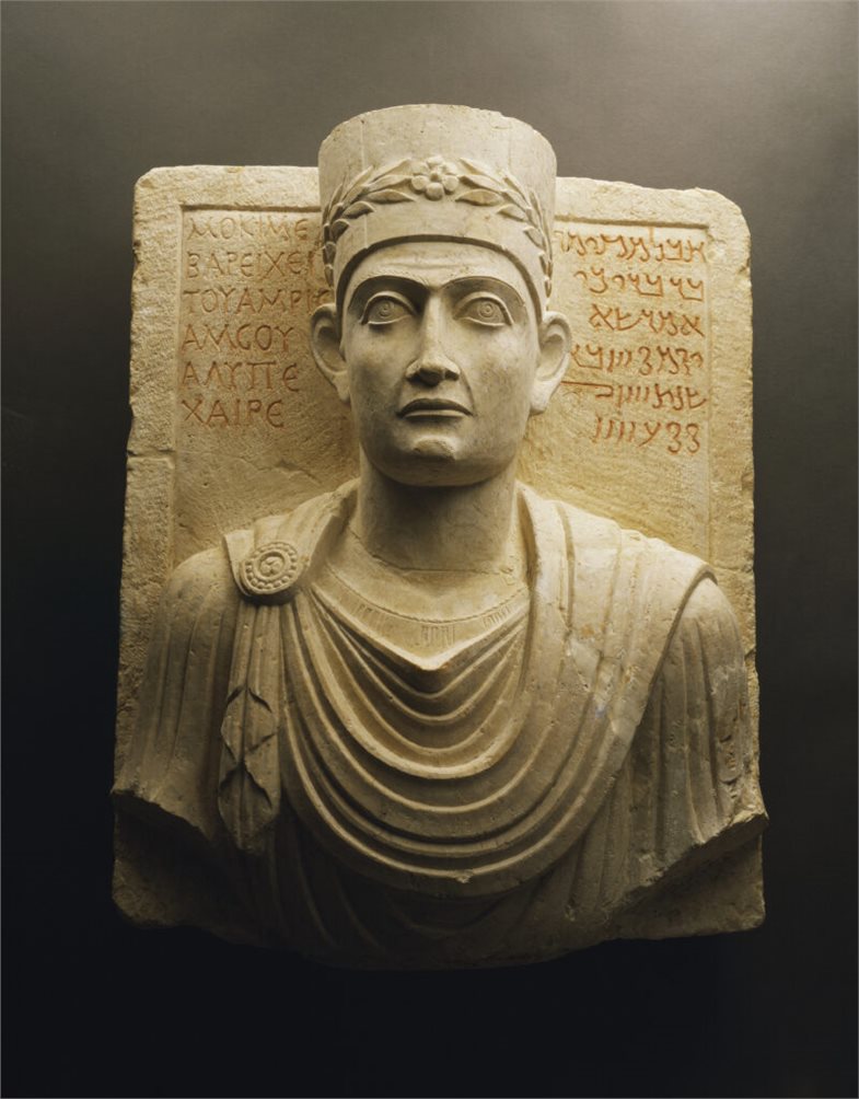 Grabrelief eines Priesters aus Palmyra mit Büste des Verstorbenen sowie der Grabinschrift auf Griechisch und Palmyrenisch; 1.–2. Jh. n. Chr.; Kalkstein; Höhe 53 cm, Breite 43 cm, Tiefe 23 cm; Palmyra Museum.