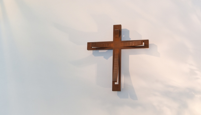 Kreuz hängt an Wand