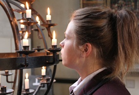 Frau in einer Kirche vor Kerzen