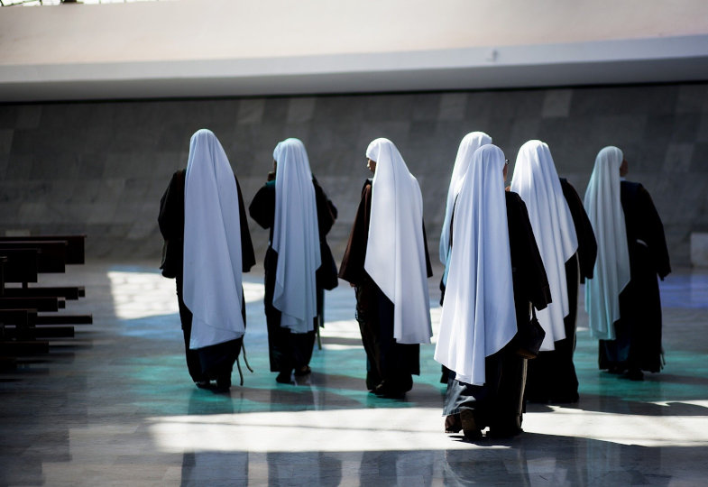 Mehrere Nonnen laufen durch eine Kirche